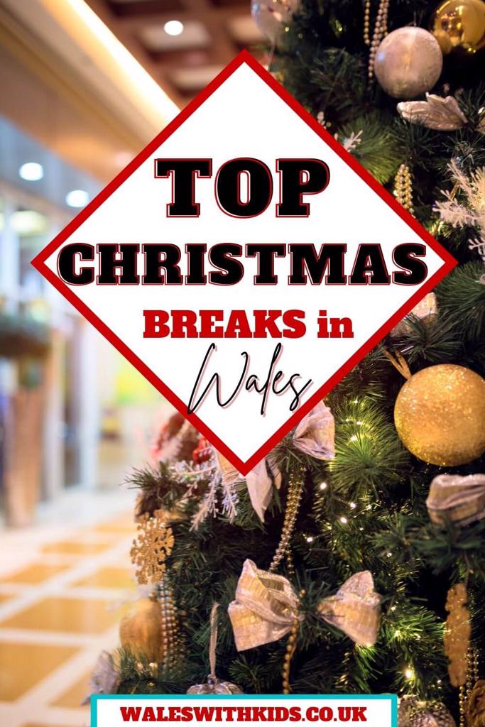 A close up of a Christmas tree with white and gold decorations and text overlay saying Top Christmas Breaks in Wales