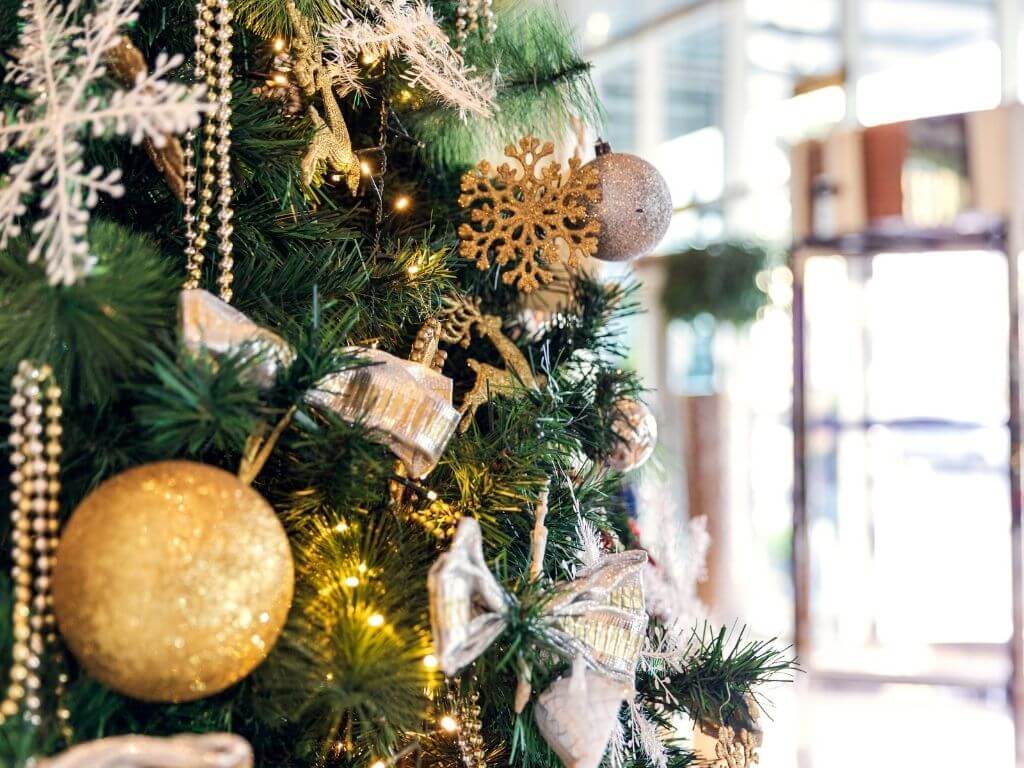 A close up of a Christmas tree with gold and white decorations