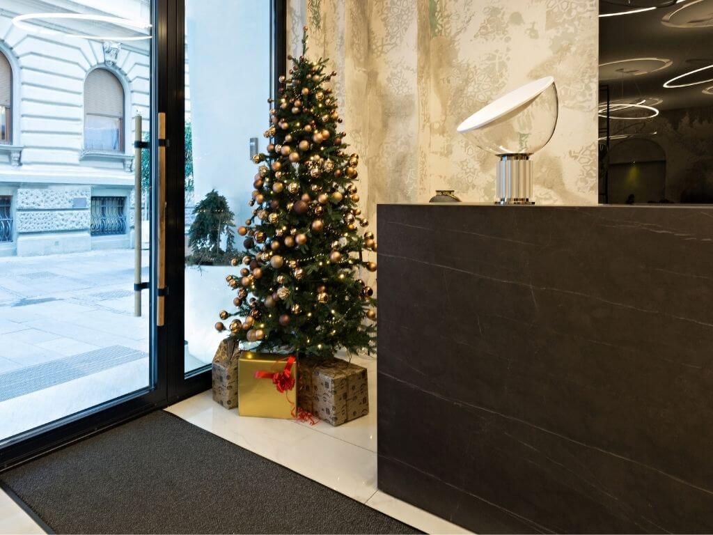 A hotel reception desk with a Christmas tree beside it