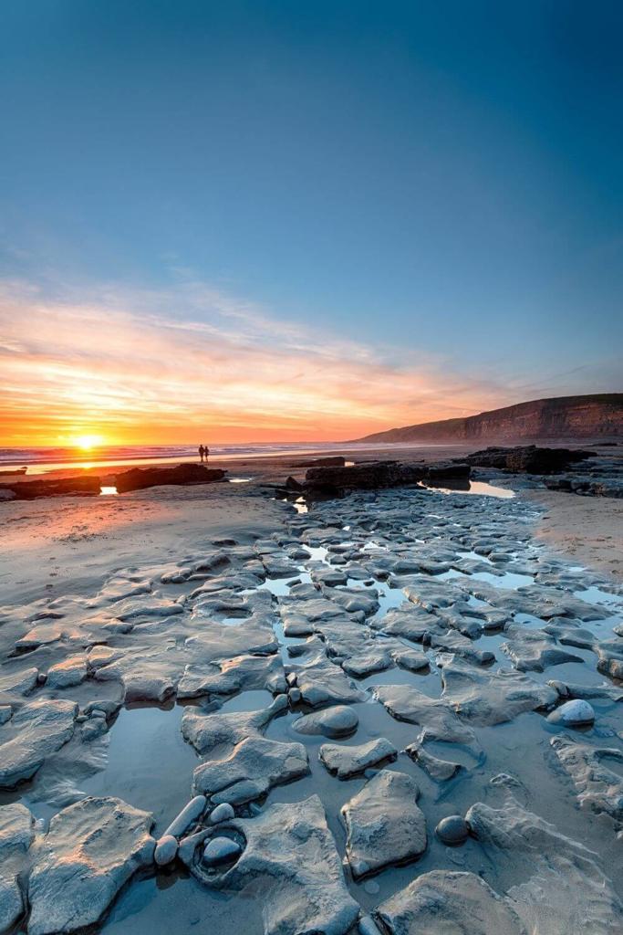 A picture of sunset over the rocky outcrops at the shoreline of Dunraven Bay in Glamorgan, South Wales