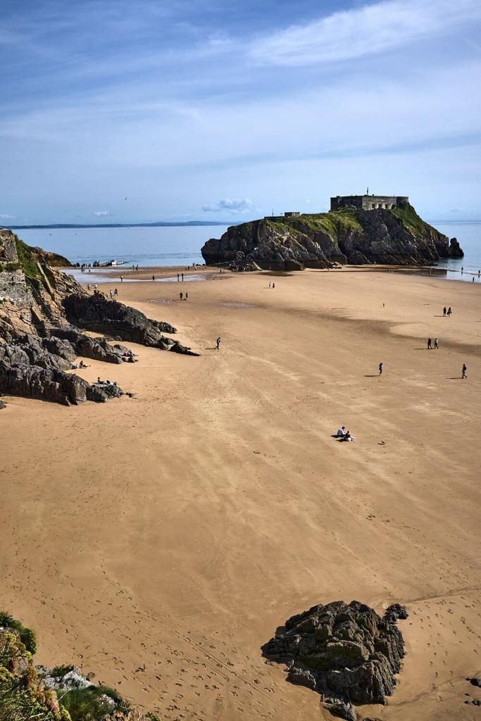 A picture of the sand beach of Tenby South Beach with a few people on the sands